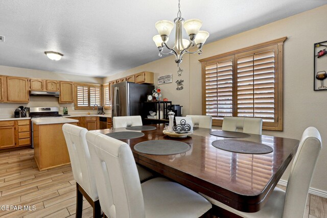 14025 Stoutland Ln, El Paso, TX 79928 - dining area with a chandelier and light wood-style flooring