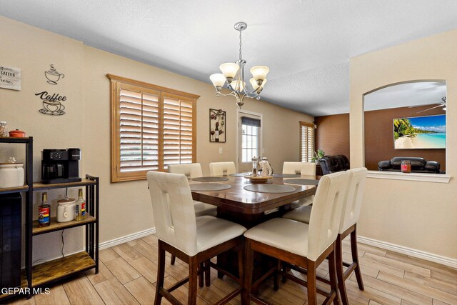 14025 Stoutland Ln, El Paso, TX 79928 - dining space featuring wood tiled floors, a chandelier, arched walkways, baseboards, and a textured ceiling