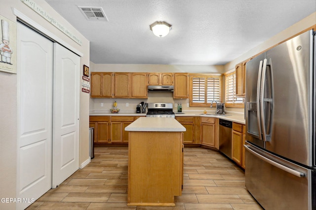 14025 Stoutland Ln, El Paso, TX 79928 - kitchen with stainless steel appliances, a sink, light countertops, wood finish floors, and a center island