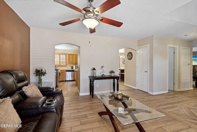 14025 Stoutland Ln, El Paso, TX 79928 - living area featuring arched walkways, ceiling fan, light wood-style flooring, a textured ceiling, and baseboards