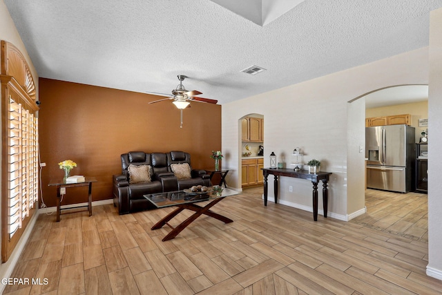 14025 Stoutland Ln, El Paso, TX 79928 - living room featuring arched walkways, light wood-style floors, ceiling fan, a textured ceiling, and baseboards