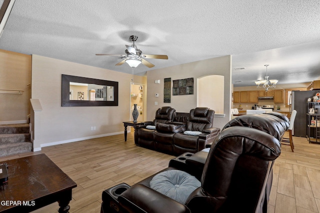 14025 Stoutland Ln, El Paso, TX 79928 - living area featuring light wood-style floors, a ceiling fan, baseboards, a chandelier, and a textured ceiling