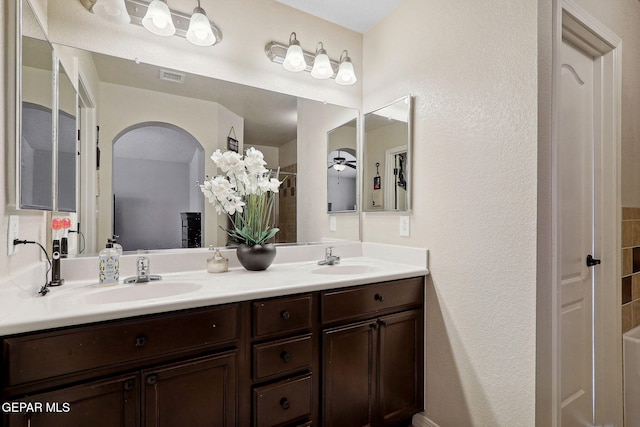 14309 Coyote Trl, El Paso, TX 79938 - bathroom with double vanity, a textured wall, and ceiling fan