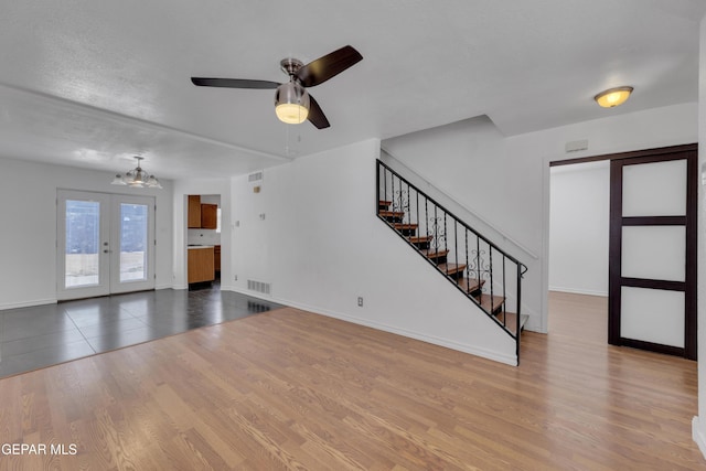 5424 Fire Ridge Cir, El Paso, TX 79932 - unfurnished living room with a chandelier, wood finished floors, stairway, a ceiling fan, and french doors