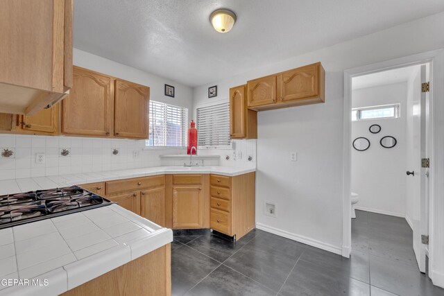 5424 Fire Ridge Cir, El Paso, TX 79932 - kitchen with tile counters, a sink, backsplash, and healthy amount of natural light