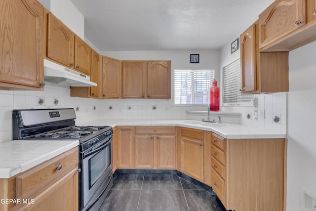 5424 Fire Ridge Cir, El Paso, TX 79932 - kitchen with gas range, under cabinet range hood, a sink, and tile counters