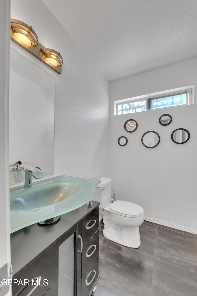 5424 Fire Ridge Cir, El Paso, TX 79932 - half bathroom featuring vanity, toilet, and a textured ceiling