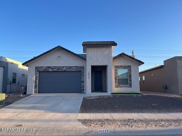 14772 John Mcneely Ave, El Paso, TX 79938 - view of front facade with stucco siding, an attached garage, driveway, a tiled roof, and stone siding