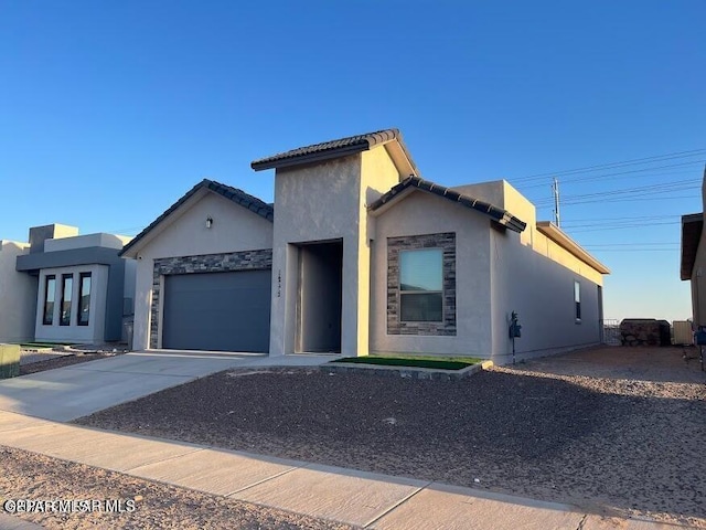 14772 John Mcneely Ave, El Paso, TX 79938 - view of front of property with an attached garage, concrete driveway, stucco siding, and stone siding