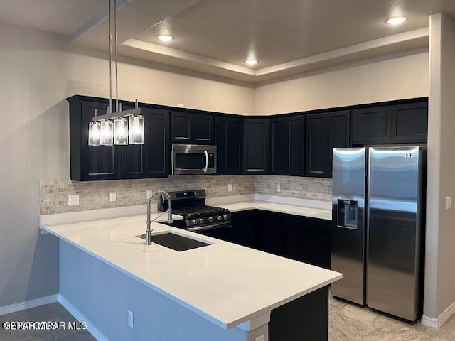 14772 John Mcneely Ave, El Paso, TX 79938 - kitchen with stainless steel appliances, dark cabinets, a sink, a peninsula, and decorative backsplash