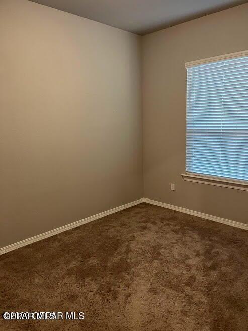 14772 John Mcneely Ave, El Paso, TX 79938 - empty room featuring dark colored carpet and baseboards