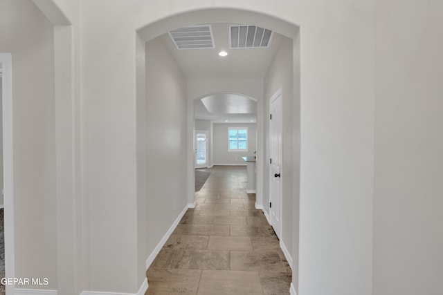 12776 Runway Ave, El Paso, TX 79928 - corridor with arched walkways, baseboards, stone tile floors, and recessed lighting