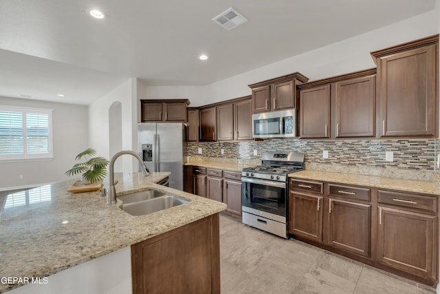 12776 Runway Ave, El Paso, TX 79928 - kitchen featuring appliances with stainless steel finishes, a sink, backsplash, light stone countertops, and recessed lighting