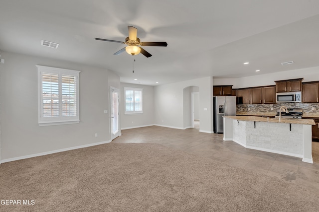 12776 Runway Ave, El Paso, TX 79928 - unfurnished living room with arched walkways, ceiling fan, recessed lighting, baseboards, and a sink