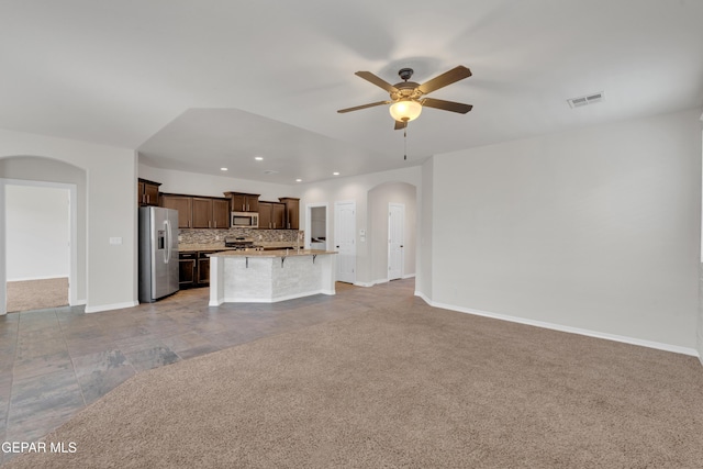 12776 Runway Ave, El Paso, TX 79928 - unfurnished living room featuring arched walkways, ceiling fan, recessed lighting, baseboards, and light colored carpet