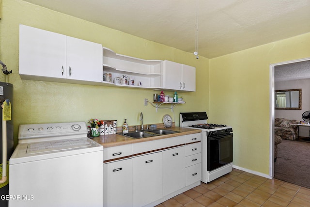 211 Green Haven Pl, El Paso, TX 79907 - kitchen with washer / clothes dryer, range with gas cooktop, a sink, white cabinetry, and light tile patterned floors