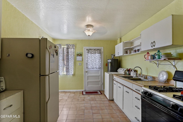 211 Green Haven Pl, El Paso, TX 79907 - kitchen featuring range with gas cooktop, open shelves, freestanding refrigerator, washer / dryer, and a sink