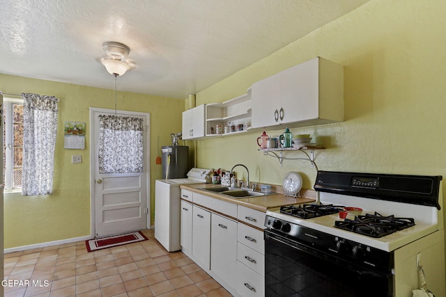 211 Green Haven Pl, El Paso, TX 79907 - kitchen featuring gas range oven, washer / clothes dryer, open shelves, a sink, and light countertops