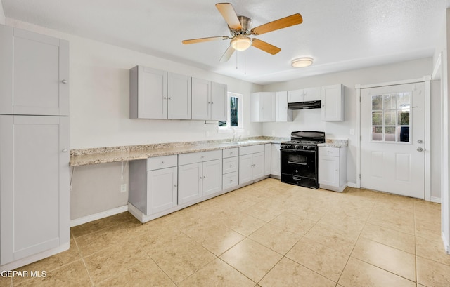 729 Delhi Dr, Socorro, TX 79927 - kitchen with gas stove, under cabinet range hood, baseboards, a ceiling fan, and a sink