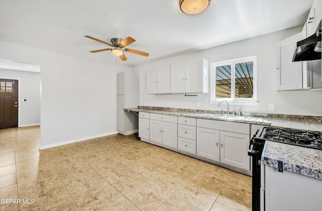 729 Delhi Dr, Socorro, TX 79927 - kitchen with gas stove, a sink, a ceiling fan, white cabinetry, and light countertops