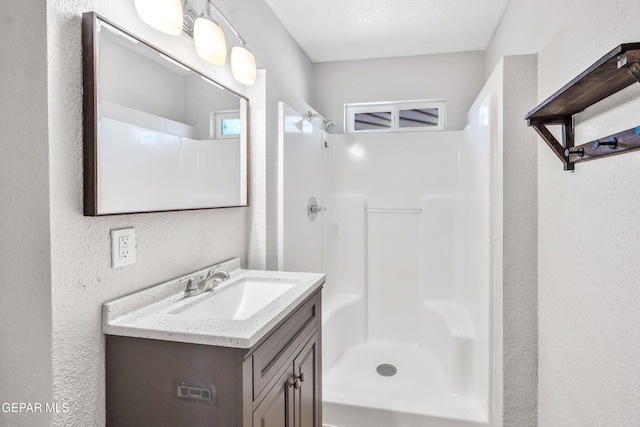 729 Delhi Dr, Socorro, TX 79927 - bathroom with a textured wall, vanity, and a walk in shower