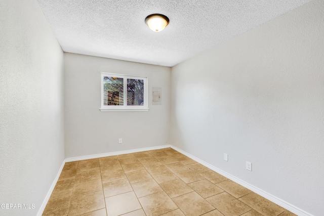 729 Delhi Dr, Socorro, TX 79927 - unfurnished room with light tile patterned floors, a textured ceiling, and baseboards