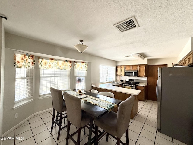 3224 Seabrook St, El Paso, TX 79936 - dining area with light tile patterned floors, a textured ceiling, and baseboards