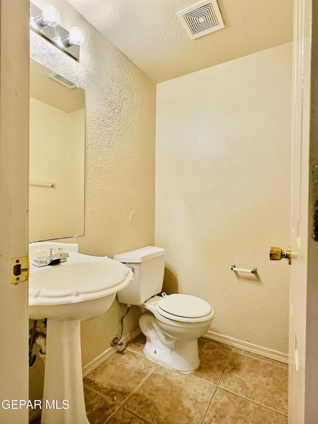 549 Northwyck Way, El Paso, TX 79928 - half bathroom featuring toilet, baseboards, a textured wall, tile patterned flooring, and a textured ceiling