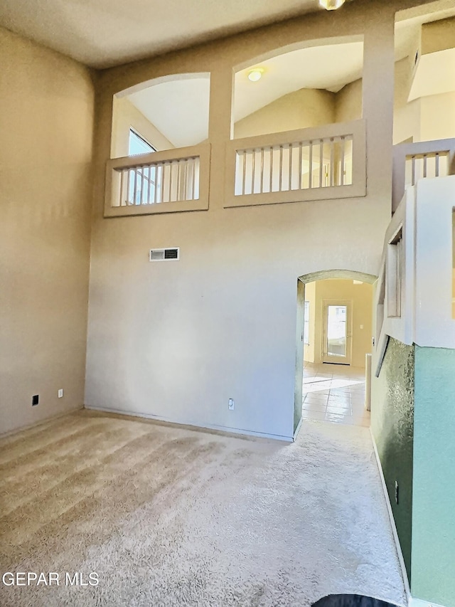 549 Northwyck Way, El Paso, TX 79928 - carpeted empty room featuring arched walkways, plenty of natural light, and a towering ceiling