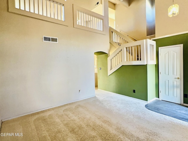 549 Northwyck Way, El Paso, TX 79928 - unfurnished living room featuring carpet flooring, arched walkways, a high ceiling, and baseboards