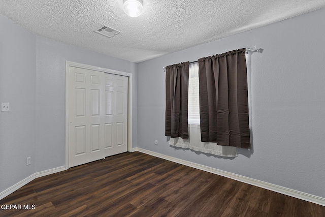 1461 Luz De Luna Pl, El Paso, TX 79912 - unfurnished bedroom with dark wood-type flooring, a closet, baseboards, and a textured ceiling