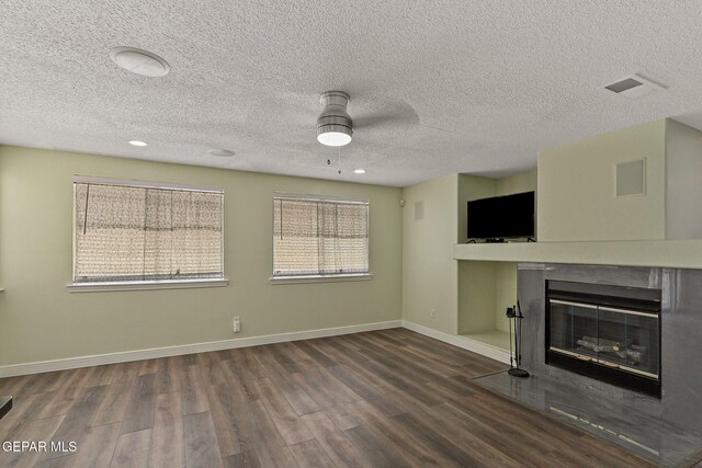1461 Luz De Luna Pl, El Paso, TX 79912 - unfurnished living room with a ceiling fan, wood finished floors, a fireplace with flush hearth, baseboards, and a textured ceiling