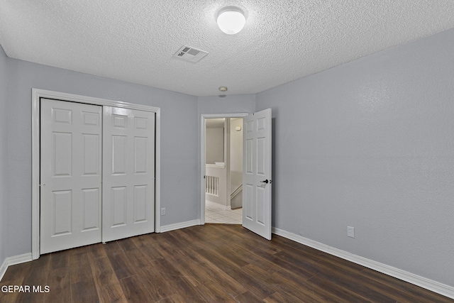 1461 Luz De Luna Pl, El Paso, TX 79912 - unfurnished bedroom with wood finished floors, baseboards, a closet, and a textured ceiling