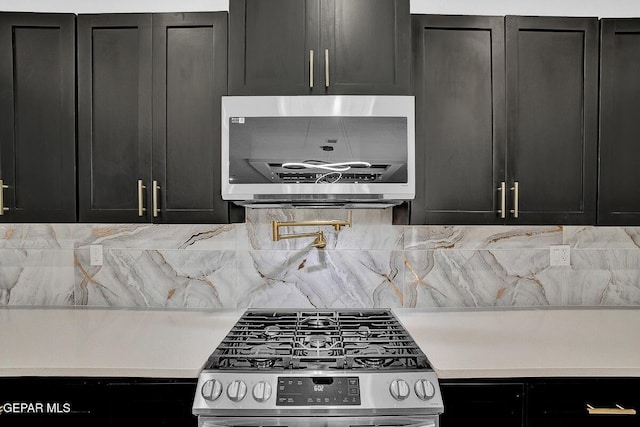 12036 Cotton Cloud Way, Socorro, TX 79927 - kitchen featuring stainless steel appliances, dark cabinetry, light countertops, and backsplash