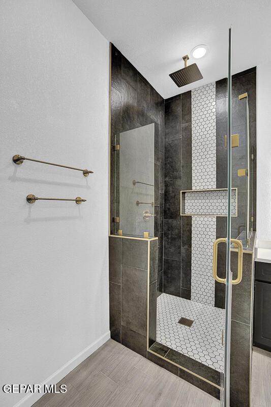 12036 Cotton Cloud Way, Socorro, TX 79927 - bathroom with a shower stall, baseboards, and wood finished floors