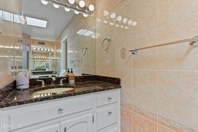 1428 Camino Alto Rd, El Paso, TX 79902 - bathroom with tile walls, vanity, and a skylight