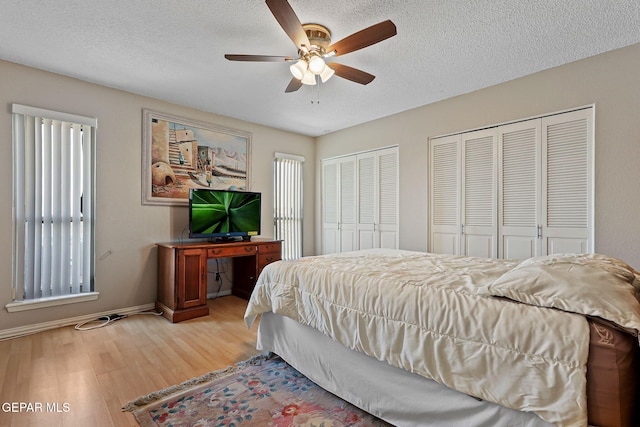 1428 Camino Alto Rd, El Paso, TX 79902 - bedroom featuring light wood-type flooring, multiple closets, baseboards, a textured ceiling, and multiple windows