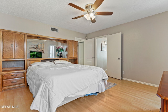1428 Camino Alto Rd, El Paso, TX 79902 - bedroom with baseboards, light wood finished floors, a textured ceiling, and a ceiling fan