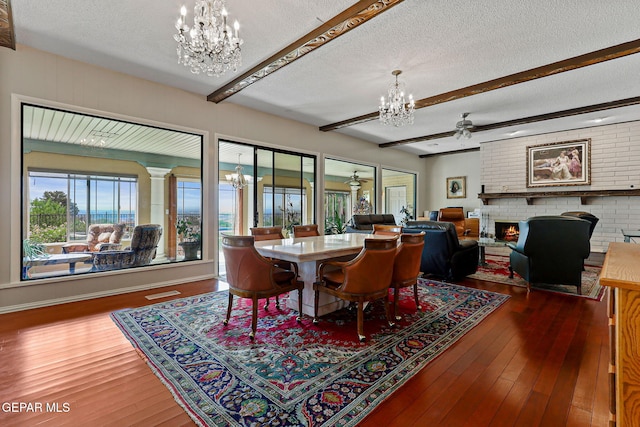 1428 Camino Alto Rd, El Paso, TX 79902 - dining space with a chandelier, a brick fireplace, a textured ceiling, beamed ceiling, and wood-type flooring