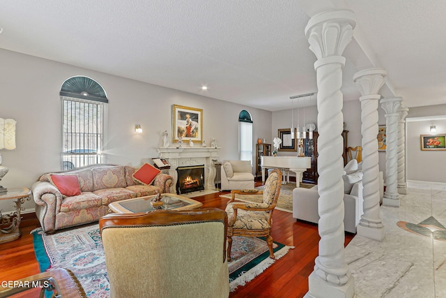 1428 Camino Alto Rd, El Paso, TX 79902 - living room featuring ornate columns, a fireplace, wood finished floors, a textured ceiling, and recessed lighting