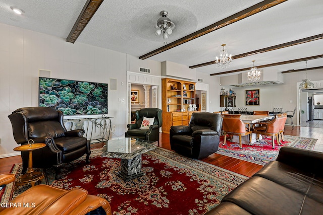 1428 Camino Alto Rd, El Paso, TX 79902 - living room featuring wood finished floors, a chandelier, beam ceiling, and a textured ceiling