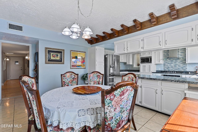 1428 Camino Alto Rd, El Paso, TX 79902 - dining space featuring light tile patterned floors, a chandelier, and a textured ceiling