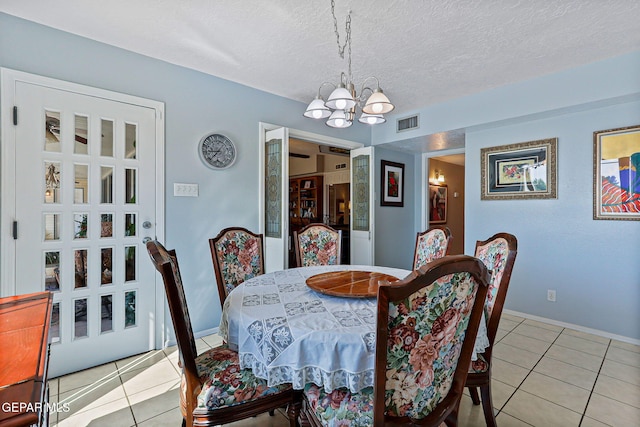 1428 Camino Alto Rd, El Paso, TX 79902 - dining area with a chandelier, tile patterned flooring, baseboards, and a textured ceiling