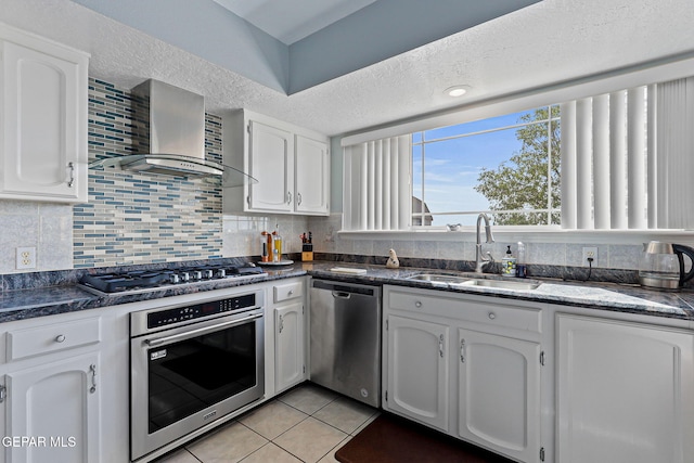 1428 Camino Alto Rd, El Paso, TX 79902 - kitchen featuring appliances with stainless steel finishes, wall chimney exhaust hood, a sink, and white cabinetry