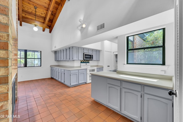 724 Gary Ln, El Paso, TX 79922 - kitchen featuring range with two ovens, stainless steel microwave, wood ceiling with exposed beams, gray cabinets, and high vaulted ceiling