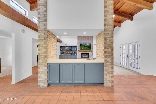 724 Gary Ln, El Paso, TX 79922 - unfurnished living room with a high ceiling, decorative columns, wooden ceiling with exposed beams, light tile patterned floors, and baseboards