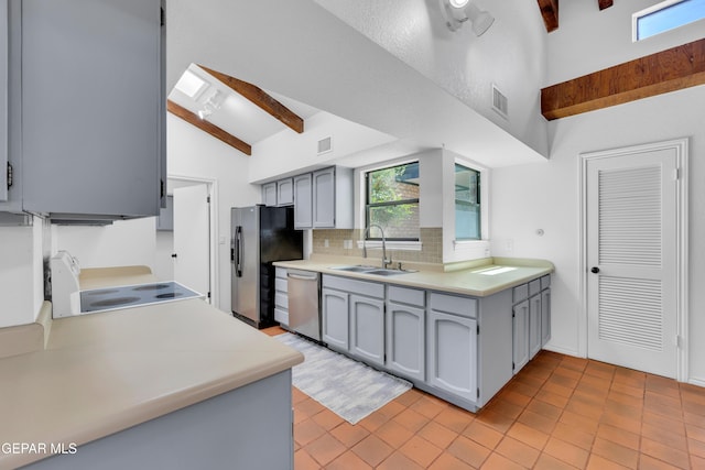724 Gary Ln, El Paso, TX 79922 - kitchen with appliances with stainless steel finishes, a sink, beam ceiling, decorative backsplash, and gray cabinetry
