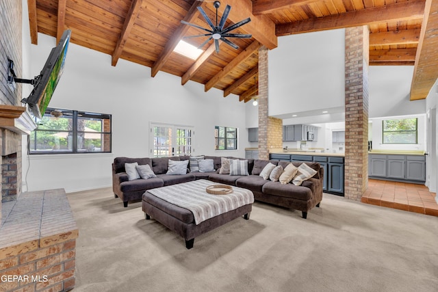724 Gary Ln, El Paso, TX 79922 - living area with high vaulted ceiling, light colored carpet, wood ceiling with exposed beams, a ceiling fan, and a brick fireplace