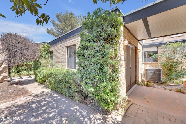 724 Gary Ln, El Paso, TX 79922 - view of side of home featuring cooling unit, brick siding, and a patio