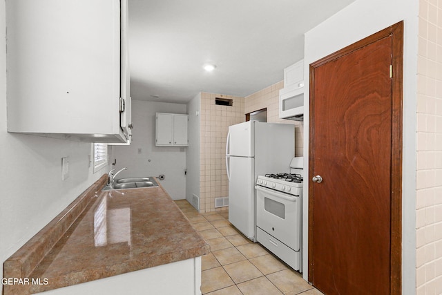 5609 Paradise Ln, El Paso, TX 79924 - kitchen with white appliances, a sink, white cabinetry, and light tile patterned floors